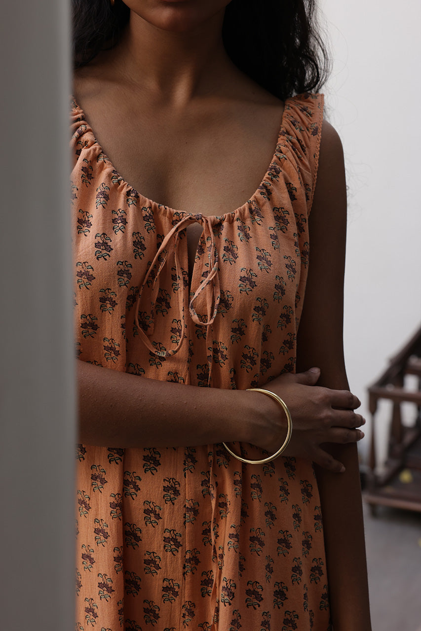 Sundress Midi Peach — ghost flat lay product shot, dress laid flat showing full silhouette, peach floral hand block print cotton, sleeveless midi sundress, Daughters of India | artisan Jaipur India