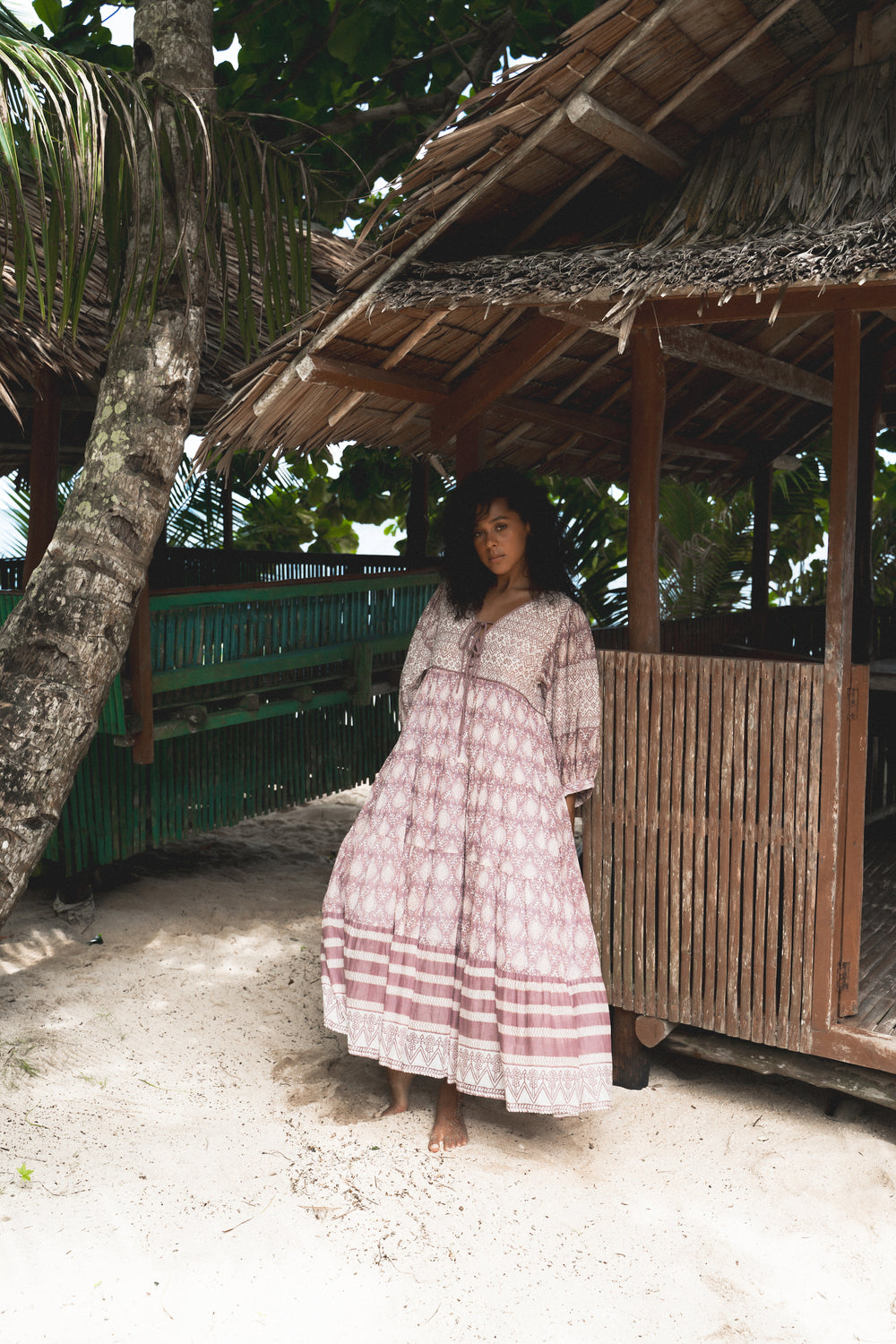 Daughters of India Jasmine Maxi Dress in Lavender — full length standing barefoot by thatched beach hut, hand screen print cotton