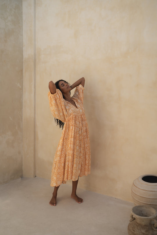 Daughters of India Kyra Midi Dress in Tangerine — standing by sand wall with clay pots, cotton